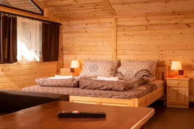 a living room with a couch in a log cabin at Почивна станция Сомат in Dospat