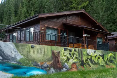 a log cabin with a painting on the wall at Почивна станция Сомат in Dospat