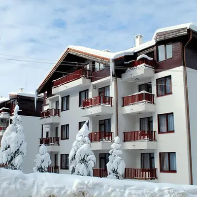 a building with snow covered trees in front of it at Apart Hotel Flora Residence - Clover Building Flat 09 in Borovets