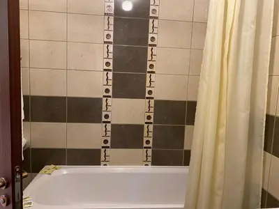 a bathroom with a tub and a shower curtain at Apart Hotel Flora Residence - Clover Building Flat 09 in Borovets