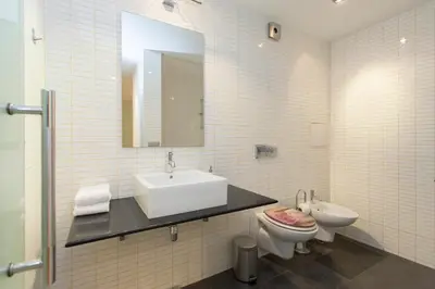 a bathroom with a sink and a toilet and a mirror at Modern Apartment in the City Center in Sofia