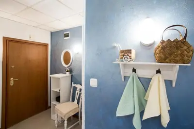 a bathroom with blue walls and a white shelf and towels at TOP CENTER Designer studio 1 minute to NDK&Vitosha by Flat Mаnager in Sofia
