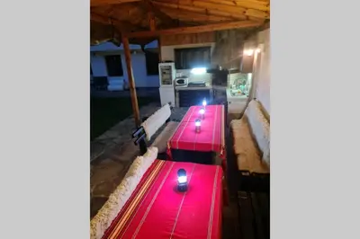 a row of red picnic tables with candles on them at Двете къщи в планината in Beli Osŭm