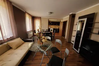 a living room with a couch and a glass table at Двете къщи в планината in Beli Osŭm