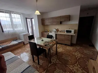 a living room with a table and a kitchen at Al Colosseo in Zvŭnichevo