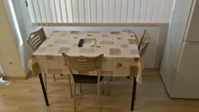 a dining room table with two chairs and a table with a tablecloth at Парк Апартаменти Юлия in Sandanski