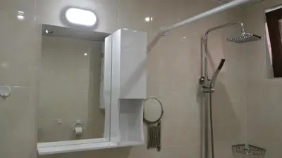 a bathroom with a shower and a mirror at Парк Апартаменти Юлия in Sandanski