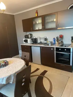 a kitchen with a table and a counter top at Гранд Манастира Пампорово in Pamporovo