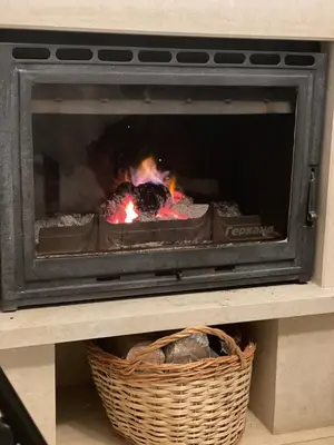 a fire in a fireplace with a basket at Гранд Манастира Пампорово in Pamporovo