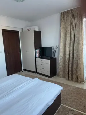 a bedroom with a bed and a dresser with a television at Гранд Манастира Пампорово in Pamporovo