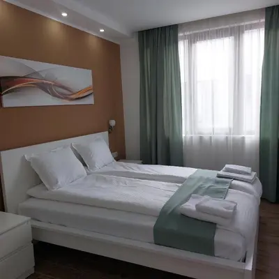 a bedroom with a large white bed with a window at Stella Guesthouse in Sapareva Banya