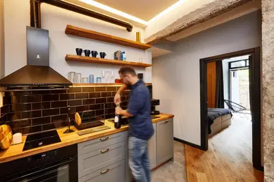 a man standing in a kitchen with a bottle of wine at COURTHOUSE #4 EXCLUSIVE Top Center PRIVATE GARDEN in Sofia