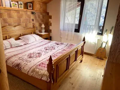 a bedroom with a large bed with a brick wall at Музикалната къща in Breze