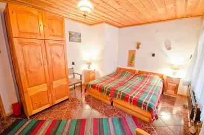a bedroom with a bed and a wooden ceiling at Palyongov Guest House in Chepelare