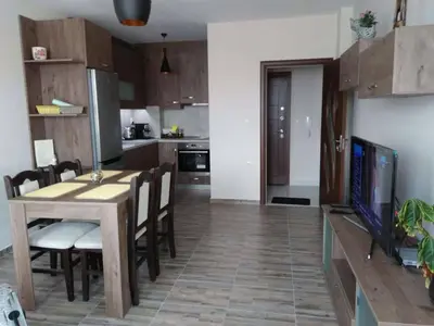 a kitchen and dining room with a table and a television at Nev Apart New in Velingrad