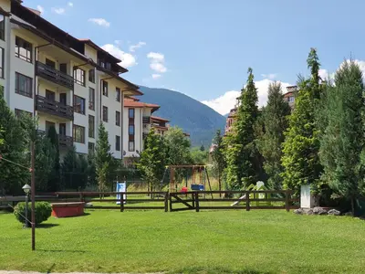 a park with a playground in the middle of a building at Family apartment VYANI in Bansko