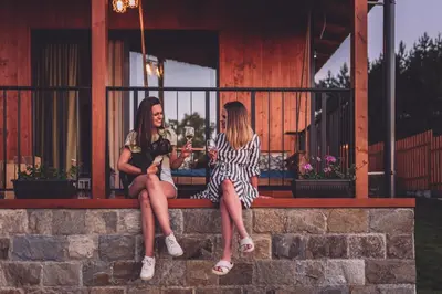 two women sitting on a ledge talking to each other at Dakota forest retreat in Tsigov Chark