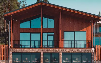 a house with glass windows and a balcony at Dakota forest retreat in Tsigov Chark