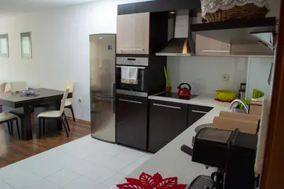 a kitchen with a stainless steel refrigerator and a table at Central Apartment Mountain View in Karlovo