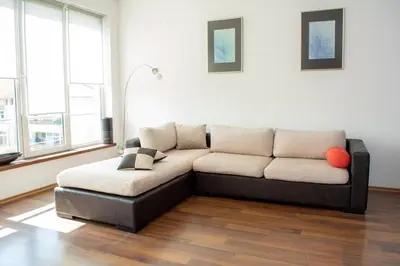 a couch sitting in a living room with windows at Central Apartment Mountain View in Karlovo