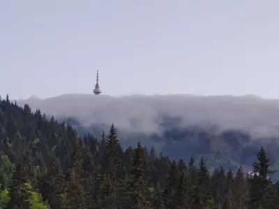 a view of a mountain with a tower in the clouds at Forest Dream Apartment - Elit Pamporovo in Pamporovo