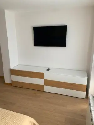 a flat screen tv on a white wall in a bedroom at Луксозна вила - Стрелча, джакузи с минерална вода in Strelcha