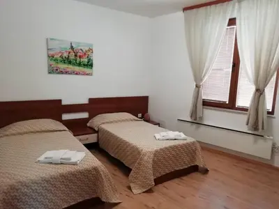 a bedroom with two beds and a window at Къща в центъра на Стрелча, джакузи с минерална вода in Strelcha