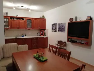 a living room with a table and a television at Къща в центъра на Стрелча, джакузи с минерална вода in Strelcha