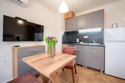 a kitchen with a wooden table with flowers in a vase at WOW studios for rent 2 bul Montevideo 25A - B in Sofia