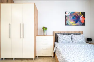a bedroom with a white cabinet and a bed at WOW studios for rent 2 bul Montevideo 25A - B in Sofia