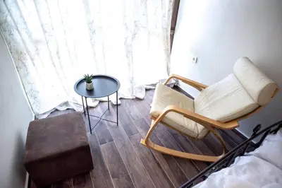 a room with a chair and a table and a window at ТАНГЕНТА стаи за гости in Oreshak