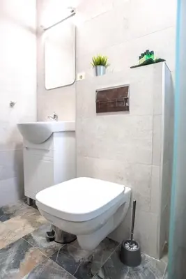 a white bathroom with a toilet and a sink at ТАНГЕНТА стаи за гости in Oreshak