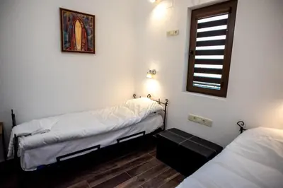 a room with two twin beds and a window at ТАНГЕНТА стаи за гости in Oreshak