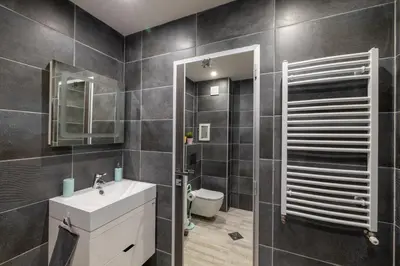 a bathroom with a sink and a toilet and a mirror at Apartment City Home in Sofia