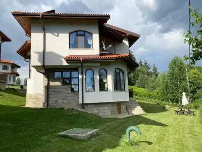 a small house in a yard with a green lawn at Cassiopea Villas in Pamporovo