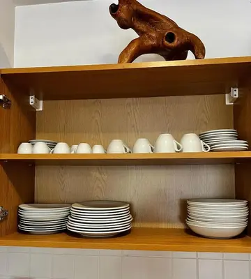 a shelf with plates and bowls and a vase at Christina Apartment in Laplandia in Pamporovo