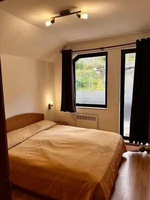 a bedroom with a bed and a large window at Christina Apartment in Laplandia in Pamporovo