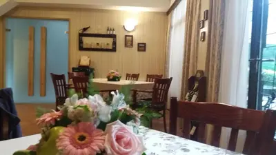 a dining room with a table with flowers on it at Hotel Perfect in Yamna