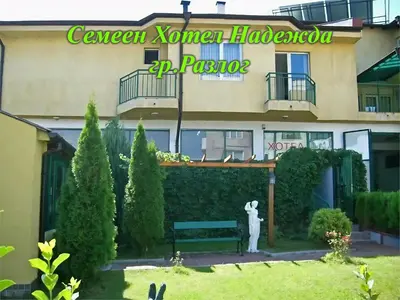 a building with a bench in front of it at Семеен Хотел Надежда in Razlog