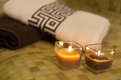 two candles on a table next to a towel at Hotel Astrea in Hisarya