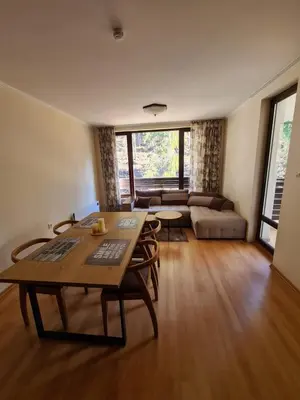 a living room with a table and a couch at Родопски Рай in Pamporovo