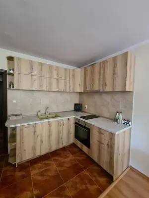 a kitchen with wooden cabinets and a sink at Родопски Рай in Pamporovo