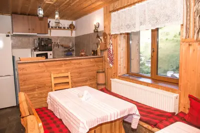 a kitchen with a table and a kitchen with a refrigerator at Villa Zaburdo in Zabŭrdo