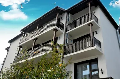a white building with balconies on it at Family Hotel and Restaurant Plamena in Oreshak