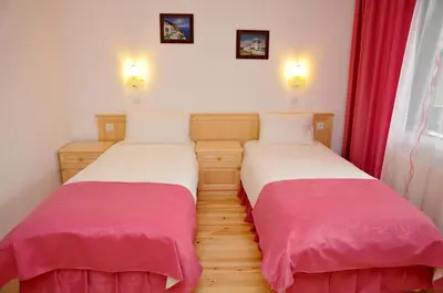 two beds sitting next to each other in a room at Family Hotel and Restaurant Plamena in Oreshak