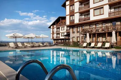 a hotel swimming pool with chairs and umbrellas at Green life Bansko, 1 bedroom private apartment D4 in Bansko