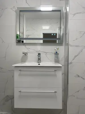 a white bathroom with a sink and a mirror at Emily & Nasi in Plovdiv