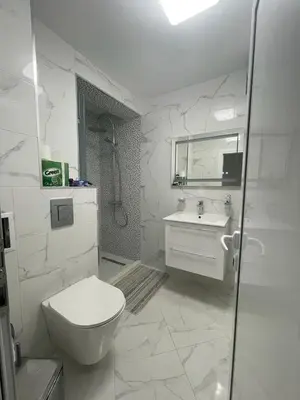 a white bathroom with a toilet and a sink at Emily & Nasi in Plovdiv