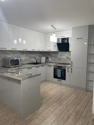 a kitchen with white cabinets and a wooden floor at Emily & Nasi in Plovdiv