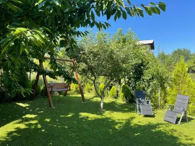 two chairs and a bench in a yard at Guest House Marchini in Sapareva Banya